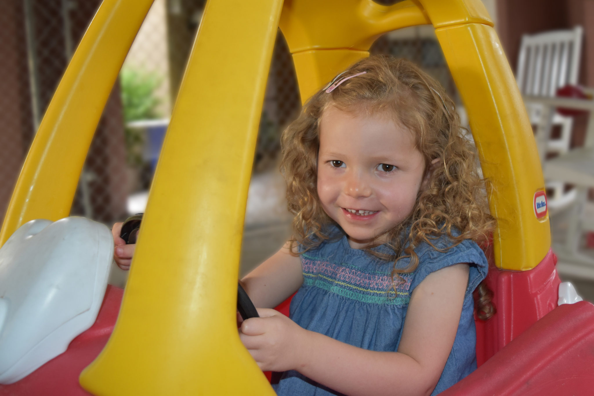 Young girl in a toy car