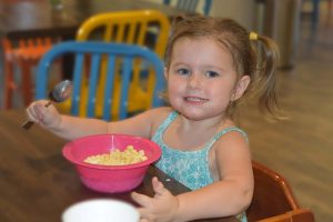 Girl enjoying a bowl of cereal in the kitchen