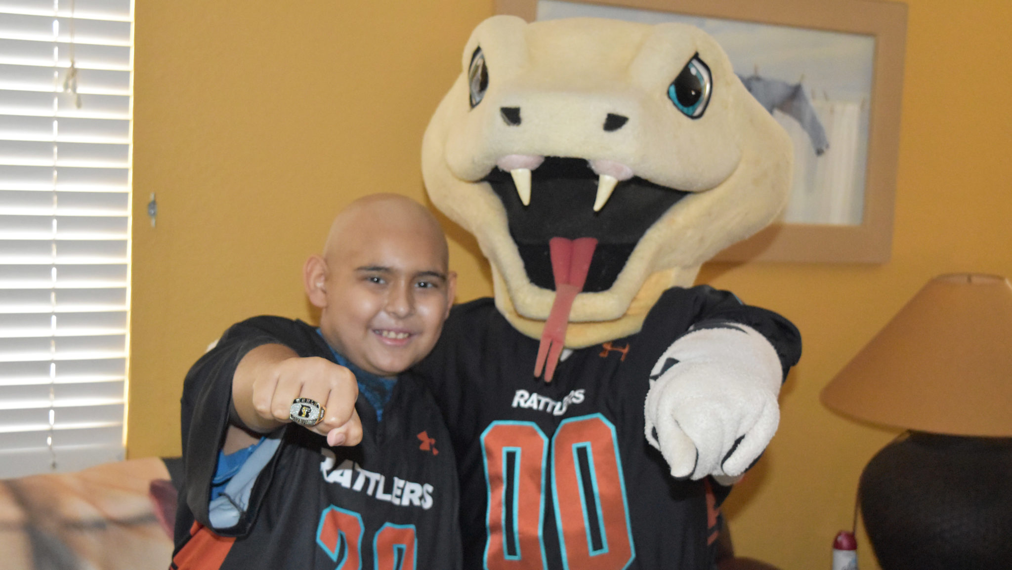 Teenage boy poses with the Arizona Rattlers' mascot