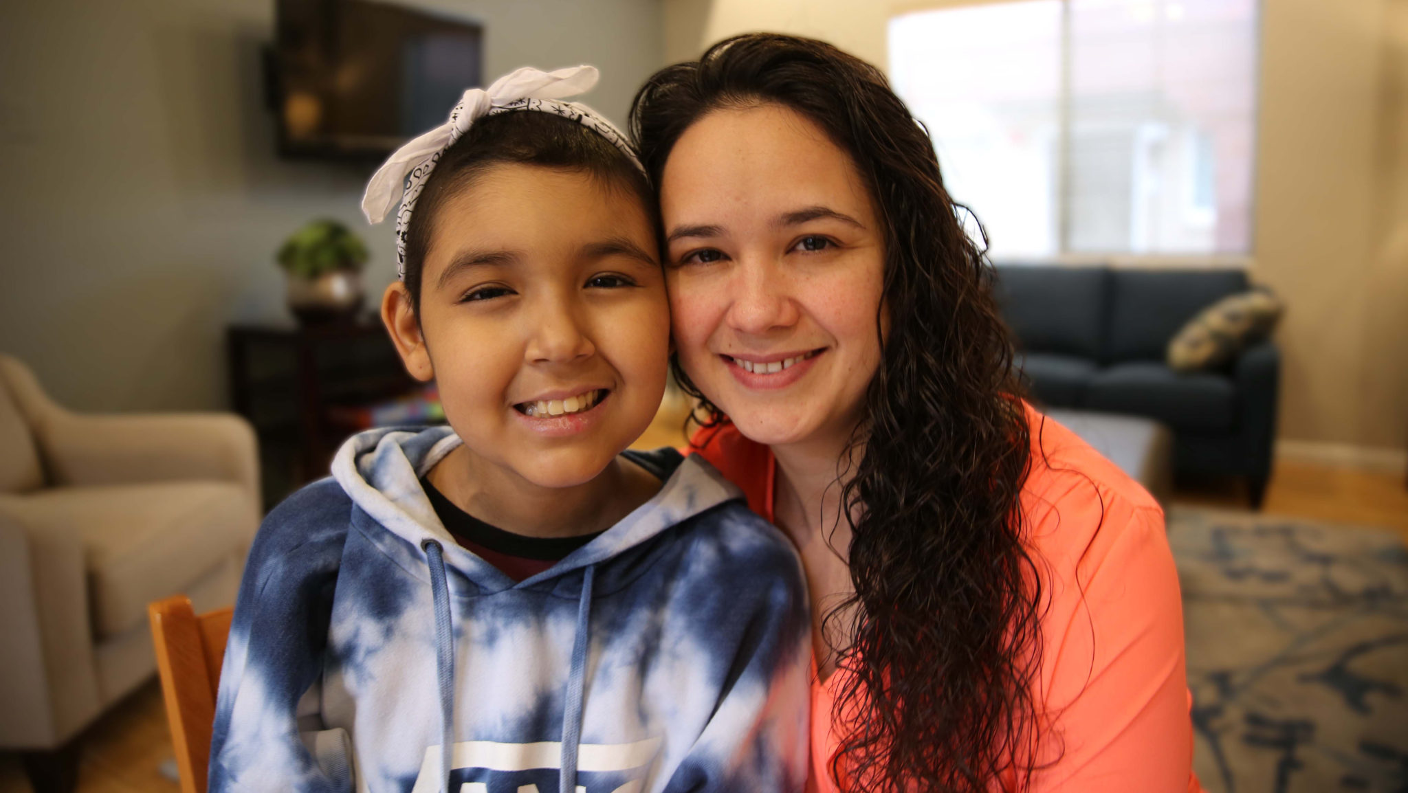 Mother and daughter smile at the camera