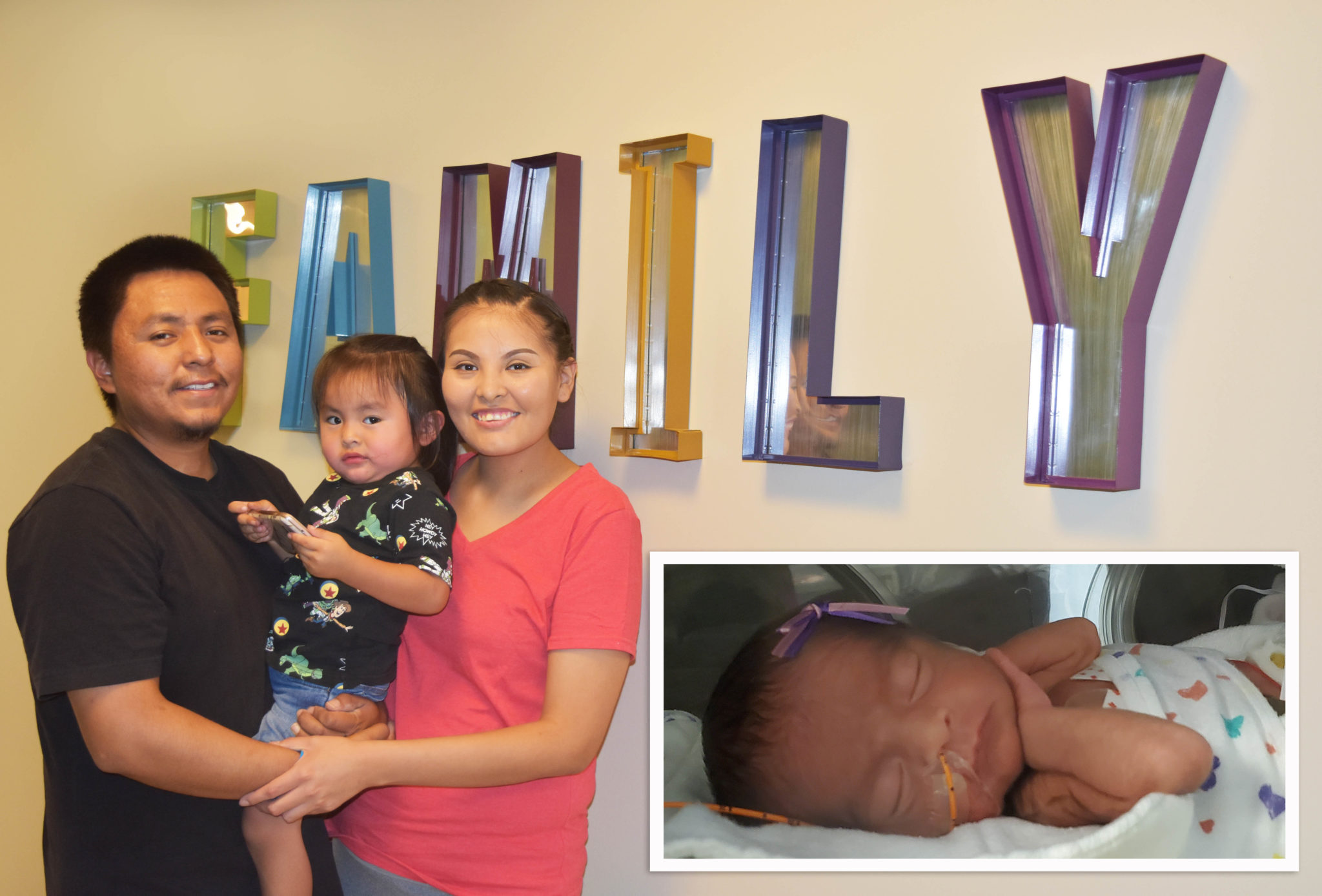 Family standing in front of a sign that says 'family'