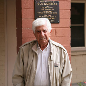 Gus Kapellas in front of the garden plaque
