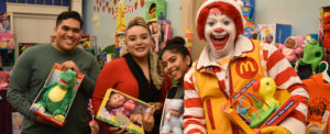 Ronald McDonald and three volunteers with donated toys